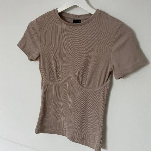 Beige t-shirt - T-shirt med söm-detalj från Gina. Nyskick 🤎