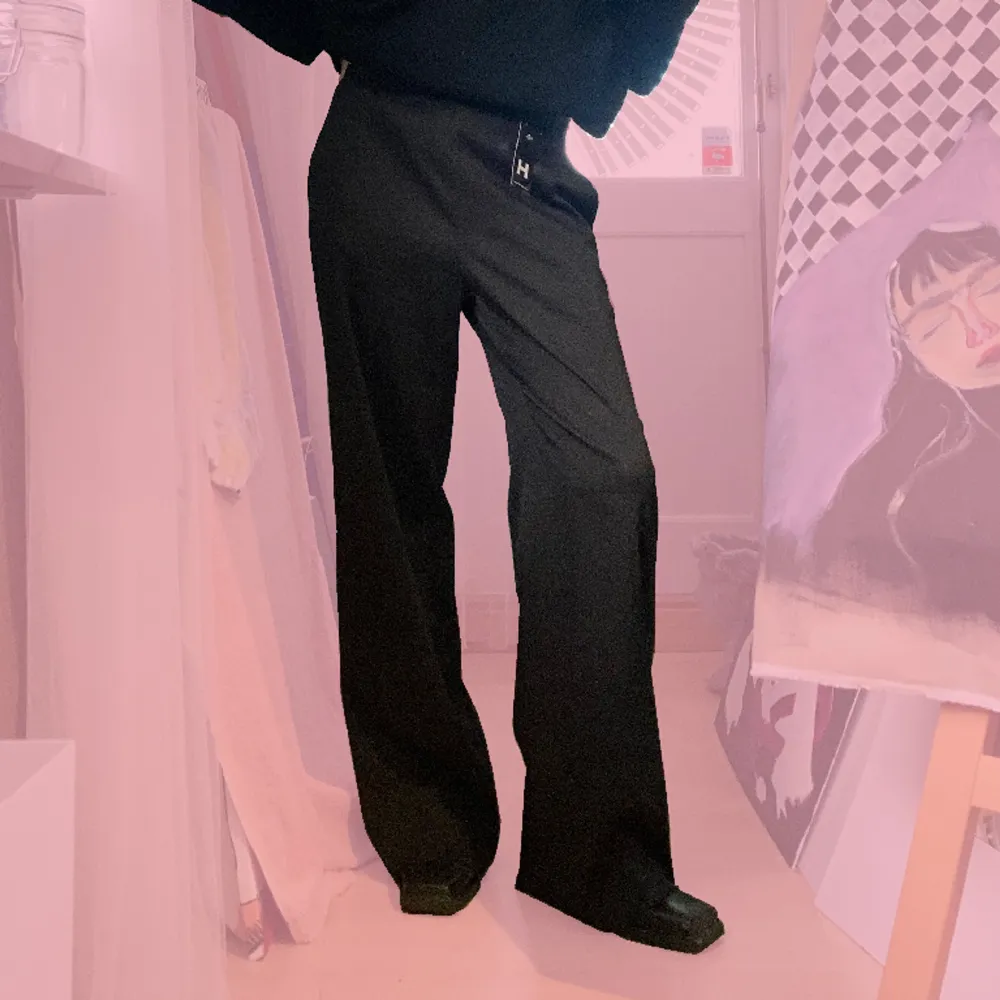 Svarta tunna kostymbyxor i polyester inköpta på Humana. Storlek 38 men går att ha baggy på storlek 34(som jag). De har fickor och en dragkedja i ena sidan. Aldrig använda (av mig) så lappen från humana sitter kvar. . Jeans & Byxor.