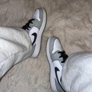 Air Jordan 1 Mid Light Smoke Grey (2022)  - Använt de sparsamt endast ett par månader så fint skick, mest lite slitna på sulan   Skosnörena var vita när jag köpte dom men jag bytte till svart!   Köpta för 2850kr på Soldout, kan visa kvitto.  Storlek EU 38.5 / US6Y 