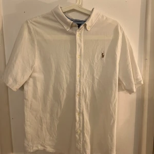 Ralph lauren skjorta - Fin skjorta i barnstorlek xl skulle säga att det passar s, Fint skick men finns spår av användning.