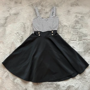 Svart och vit klänning - En super fin svart & vit klänning som jag fick i Spanien. Normal i storlek, använd fåtal gånger för flera flera år sedan. Det finns pads/kupor insydda i klänningen vid bysten. Dragkedja på ryggen, inga defekter eller andra fel på den.