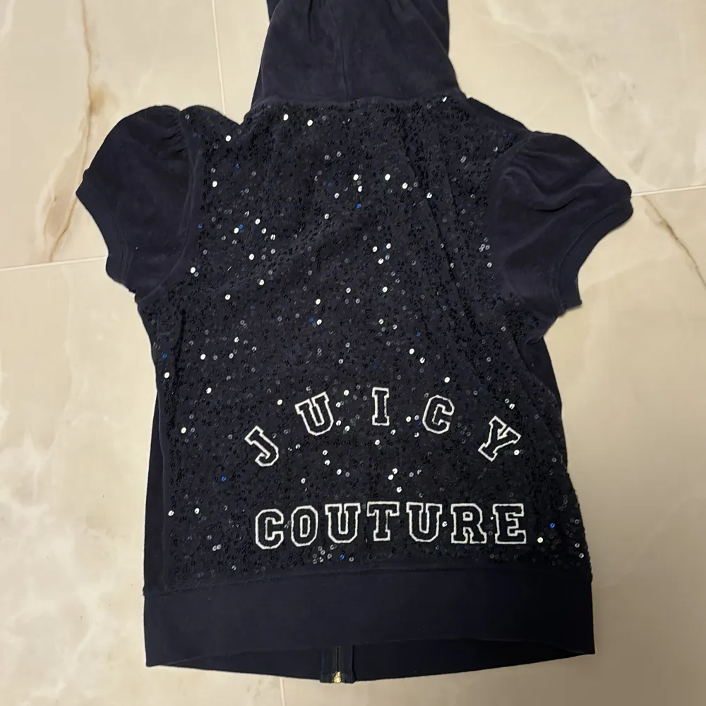 Jättegullig mörkblå Juicy Couture kofta med korta ärmar och glitter på ryggen. Så gullig men säljer då den ej kommit till användning. Den är från 2000-tal och säljs ej längre. Fint skick och inga defekter💞 storlek M men passar S. Tröjor & Koftor.