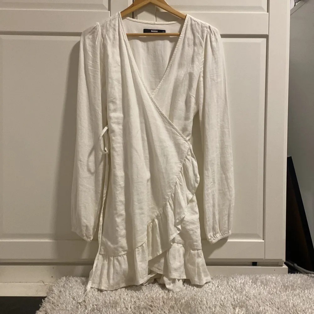 Här har vi en vit linne klänning med knytning som är perfekt till skolavslutning eller andra festligheter. Klänningen är i nyskick och har endast använts en gång.. Klänningar.