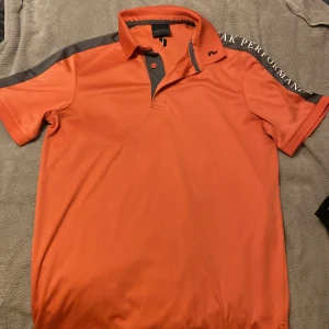 Golfpiké - En orange golf piké från peak performance i storlek S. Köparen står för frakt.