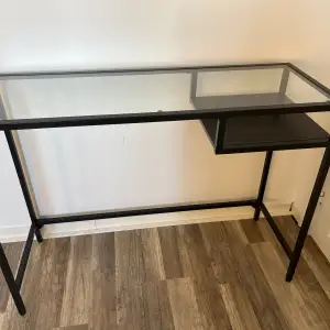 Ett praktiskt svart bord från IKEA. Har själv använt som sminkbord, funkar utmärkt. Helt okej skick enbart lite repor på glass skivan 