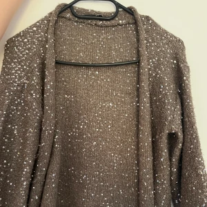 Glittrig kofta Marella - En grön/grå kofta från märket Marella, aldrig använd. Storlek L men känns som mycket mindre.