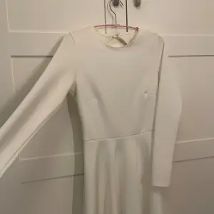 En vit student klänning från Nelly som aldrig är använd i storlek S, den är öppen i ryggen