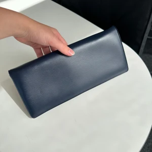 Clutch - Marinblå clutch/portmonnä med spänne och innerficka. Bra skick. Perfekt till balen eller finsittningar😍