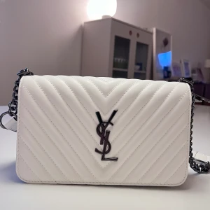YSL väska  - Aldrig använt! Säljer denna jättefina vita Yves Saint Laurent väskan (obs, inte äkta) med röd insida, i strl medium. Fick den nyligen i present och säljer då den aldrig kommit till användning. Kontakta gärna för fler bilder eller frågor 💘