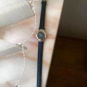 Fin svart klocka med silvriga detaljer. 30 mm och under diameter. 🖤🩶