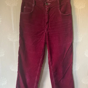 Vinröda manchesterjeans  - Superhäftiga jeans med vita sömmar & detaljer. Lila partier nertill bak på byxorna. Står ingen storlek i men passar som S/36