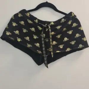 Custom made mini shorts in stretch and with gold and black satin waist band. Printed gold bee pattern.
