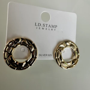 Örhängen  - De små stiftörhängena är förstklassigt och detaljrikt utformade i guld. De imponerar med en slingrande orm i naturtrogen design. Det ger det uttrycksfulla örosmycket elegant glans. Stiftörhängena passar perfekt för en extravagant, originell look.