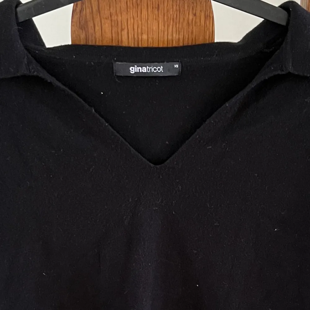 En svart stickad tröja med krage. Storlek xs. Stickat.