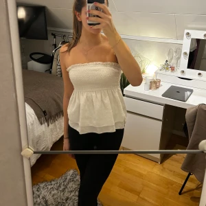 Vit tubtröja - Vit tubtröja med en volang, super söt till sommaren. Storlek XS men töjbar så passar även S. Väldigt bra skick. 50kr