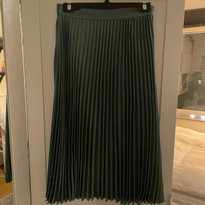 Kjol - Grön midikjol som är nästintill oanvänd och säljes därför 