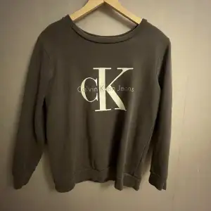 Detta är en Calvin Klein sweatshirt i storlek small💗Den är grå och det är ett stort Calvin Klein tryck på bröstet/magen. Tröjan har inga skavanker trots en del användning!😀 Hör av dig ifall du har några frågor!🥰