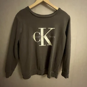 Sweatshirt Calvin Klein - Detta är en Calvin Klein sweatshirt i storlek small💗Den är grå och det är ett stort Calvin Klein tryck på bröstet/magen. Tröjan har inga skavanker trots en del användning!😀 Hör av dig ifall du har några frågor!🥰