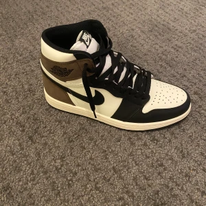 Jordan 1 mocha high - Jag säljer dessa Jordan 1 mocha i storlek 42 pågrund av att de ej passar mig. Skorna är helt oanvända och har endast används som dekoration. Vid intresse skriv!