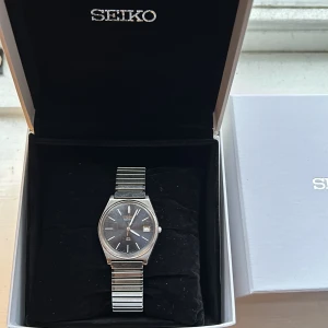 Seiko klocka - Tja säljer denna stilrena och snygga Seiko klockan, lite repigt på plast/glaset men bra kvalitet och mycket att ge (Nytt batteri) LÅDA FÖLJER EJ MED, Hör av vid funderingar!