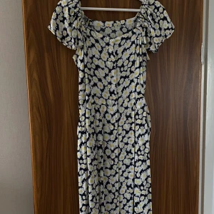 Blommig sommar klänning - Denna klänning säljs på grund av den är för liten för mig, den har blivit använt ungefär 3-5 gånger och är fotfarande ny. Storleken ör Medium. Den är gjord av material som ör bra för sommaren och den har även fick. Bältet är inkluderad.