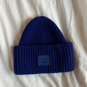 Acne mössa - Säljer denna mörkblå acne mössa i nyskick. 