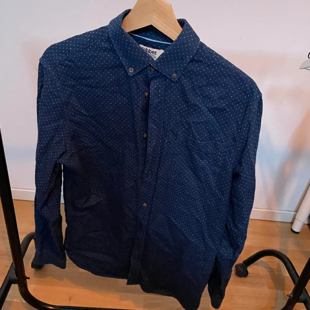 Mörkblå skjorta från Dobber S, lämnas antingen nytvättad/strykt eller båda. Skjortor.