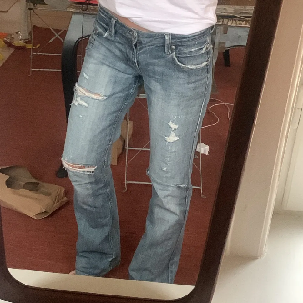 As snygga lågmidjade jeans som är Långa! Har silver detaljer fram o bak:) står ingen storlek men passar mig som brukar ha 36-38 i byxor.  Midjemått: ca 39 cm Innerbenslängden:84cm. Jeans & Byxor.