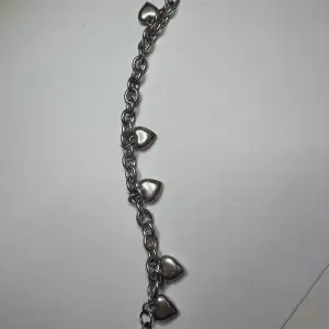 Nice bracelet with five heart charms from Snö Of Sweden.    On the silver colored heart charms is the text; SNOW OF SWEDEN.    The bracelet is made of silver-plated iron.    The logo is in silver-plated zinc.    Length; 17 - 20 cm    Width with the charms