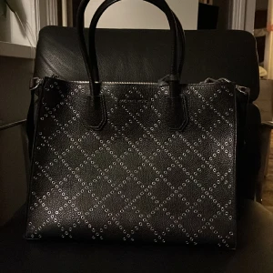 Michael Kors väska - Jättefin Michael Kors väska. Svart med silver detaljer och beige insida. Köpt för några år sedan och har inga skador. Skriv till mig om ni vill ha fler bilder.