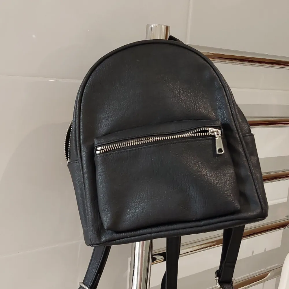 Liten svart ryggsäck med långa axelrämmar från H&M. Väskor.