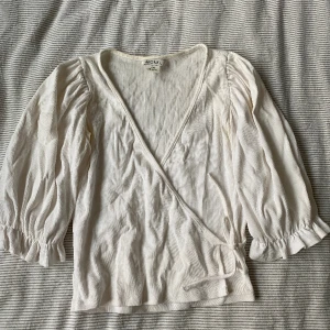 En kofta/blus från Monki - En jättefin vit kofta från monki som har använts många gånger under sommaren! Den är nu förlusten vilket är varför jag säljer den! Den har en liten missfärgning uppe i nacken pga solkräm, annars i fint skick!