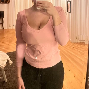 Rosa tröja  - En rosa tröja med v-ringning där fram med lite kortare armar. 