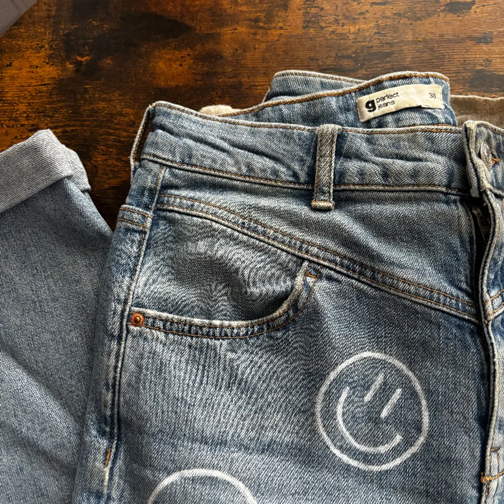 Blåa mom-jeans från gina tricot som jag själv har ritat smileys på med en vit tygpenna som håller i tvätten. Kul design men tyvärr för liten för mig!. Jeans & Byxor.
