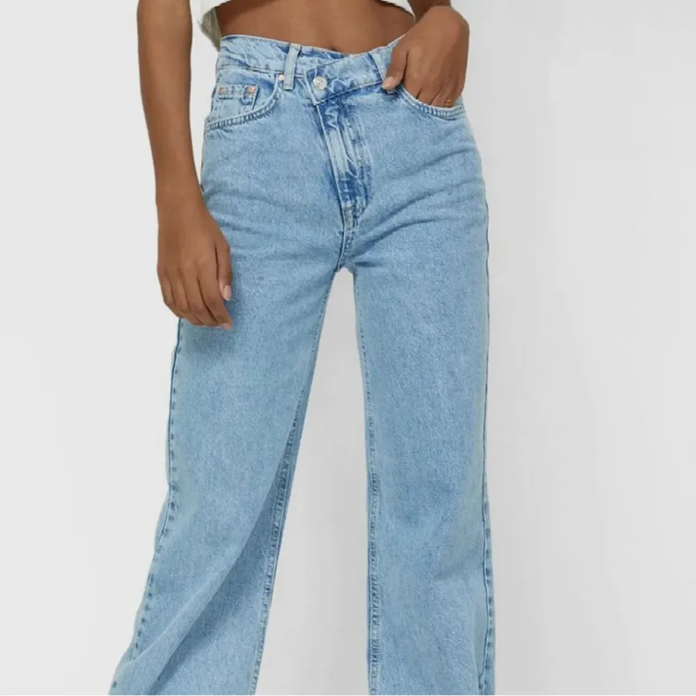 Ljusblåa jeans från stradivarius med asymmetrisk knäppning. Inga defekter . Jeans & Byxor.