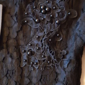 Spetsklänning med pärlbrodyr - Helt ny vintageklänning med tags.  Broderi med pärlor och undekjol i tyll. Jättesnygg.