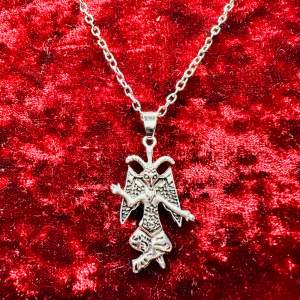 Nytt silverfärgat halsband med  Baphomets sigill - ibland kallad bockguden från Mendez. Ovanligt och originellt, ett statementsmycke om något.  Amuletten är 3 cm lång, halsbandet är cirka 50 cm långt. Låses med hummerlås. 