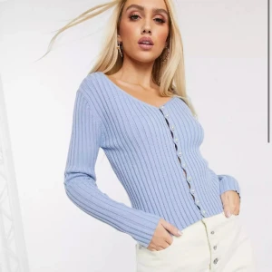 Stickad topp med pärlor  - Stickad blå topp med pärlor som knappar, köpt från Nakd för 399kr.  