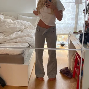 Ljusgrå lågmidjade kostymbyxor. - Så snygga ljusgråa lågmidjade kostymbyxor som tyvärr är för små för mig. Sitter så fint i rumpan och är bootcut. Jag har sytt upp dem så de går att ha mycket längre. Hör av dig vid fler frågor🩷
