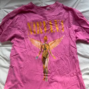 Rosa Nirvana t-shirt med orange motiv.