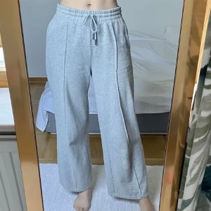 Gråa mjukisbyxor - Ginatricot - Mjukisbyxor med raka ben från Ginatricot. Endast använd ett par gånger, är som helt ny. Sitter jättefint! Köpt för 399kr, säljer för 149kr