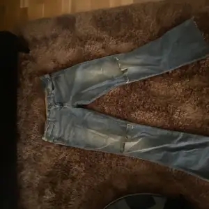 Vintage jeans från Wrangler med hål i. Lågmidjade och utsvängda Innerbenslängd:81 cm (mätt från skrevet) Midjemått:39 cm 