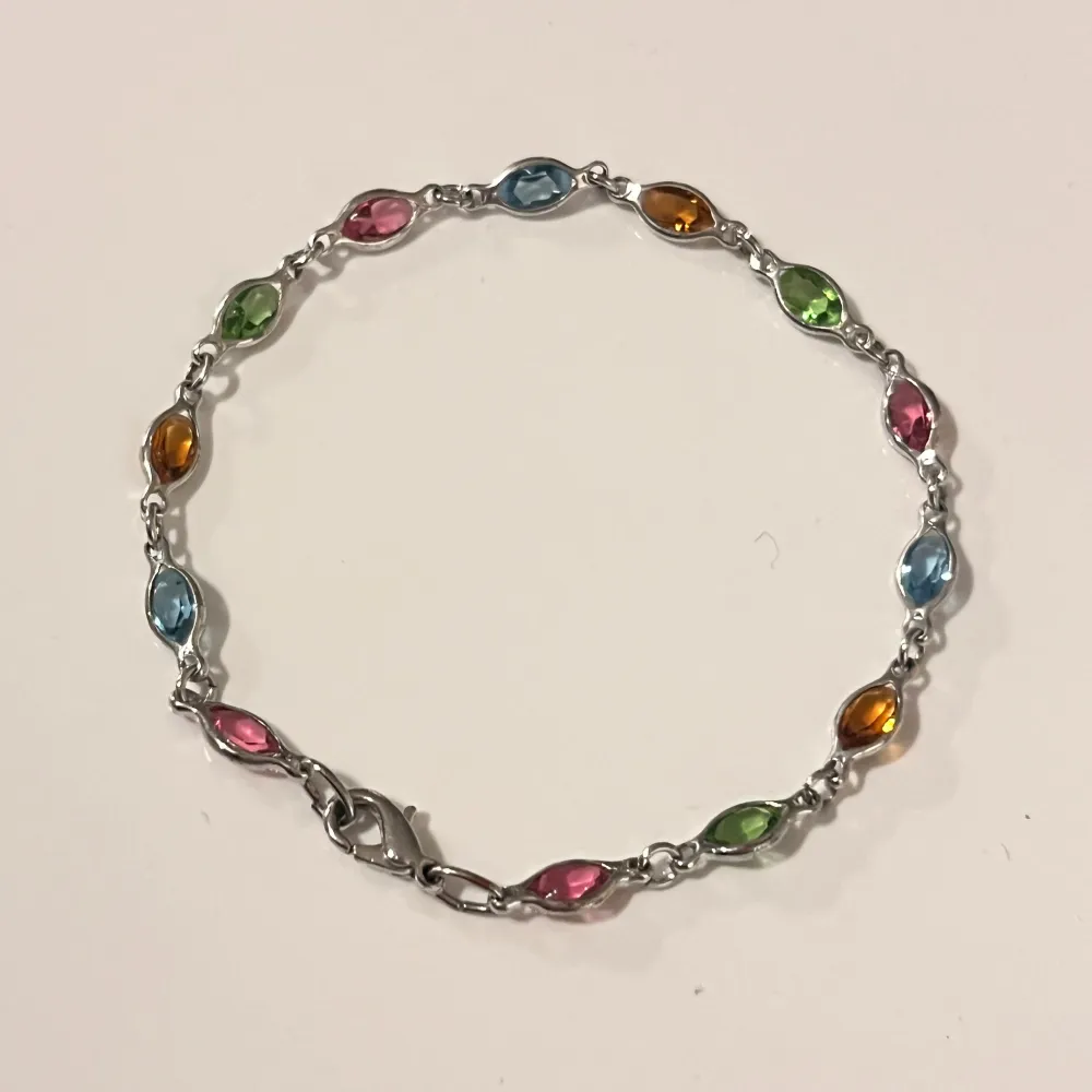 Kristall stenar i form av ett ”gemstones bracelet”. ca 17cm långt i totala längden (bild 2). Köptes runt 2010. Använt men hittar inga större anmärkningar.. Accessoarer.