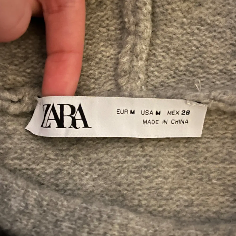 En grå mordern stickad huvtröja från Zara. Väldigt varm och mysig. Den är taightare ner till så de framhäver ens midja. Den är i väldigt bra skick, bara använts fåtal gånger. . Stickat.