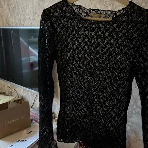 Svart spets blus - Svart genomskinlig spets blus som är använd fåtal gånger. Från NewYorker