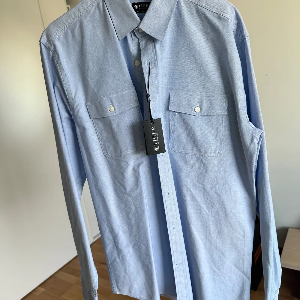 Ljusblå skjorta från Tiger of Sweden  Helt ny och oanvänd  100% bomull Storlek 40 slim fit. Skjortor.