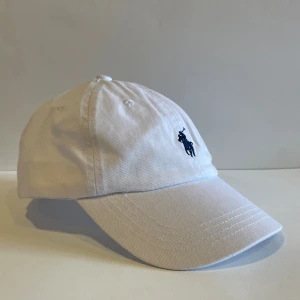 Vit Ralph Lauren Keps - Onesize, perfekt för sommaren, bra passform och populär bland tjejerna.☝️  Pris 250, går att diskuteras vid snabb affär.
