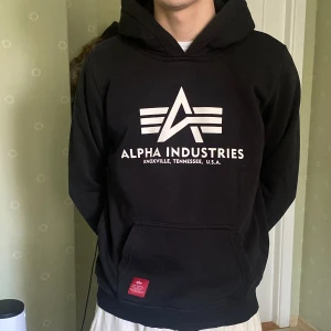 Svart Alpha Industries Hoodie - Svart alpha industries hoodie, välanvänd och har en defekt på armen (bild 3) men väldigt bra kvalitet i övrigt. Barnstorlek men passar som XS. Frakt tillkommer 🙌