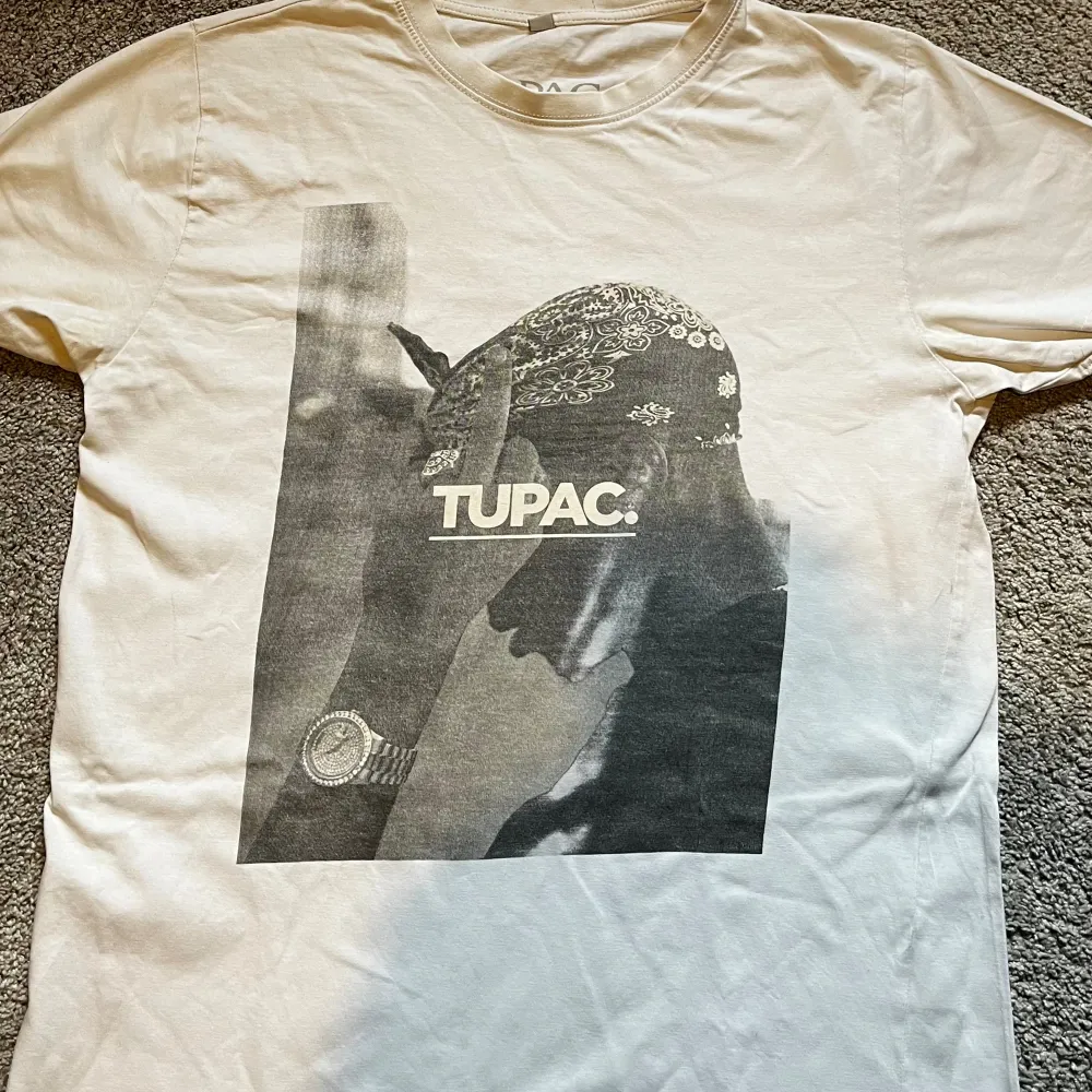En mycket stilren och vit Tupac tröja från troligen pull and bear Inga defekter då den är helt klar vit Står XL men passar mig som är M/L Pris kan diskuteras men är i nytt skick . T-shirts.
