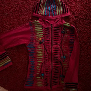 Röd hippie hoodie - Asball röd zip up tröja med massa detaljer! Knappt använd efter jag köpte den i Danmark för ett tag sen då den inte är min stil. Väldigt bekväm och sitter fint💞 meddela vid frågor!